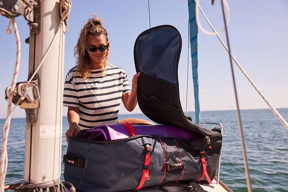 woman storing inflatable paddle board in a paddle board bag