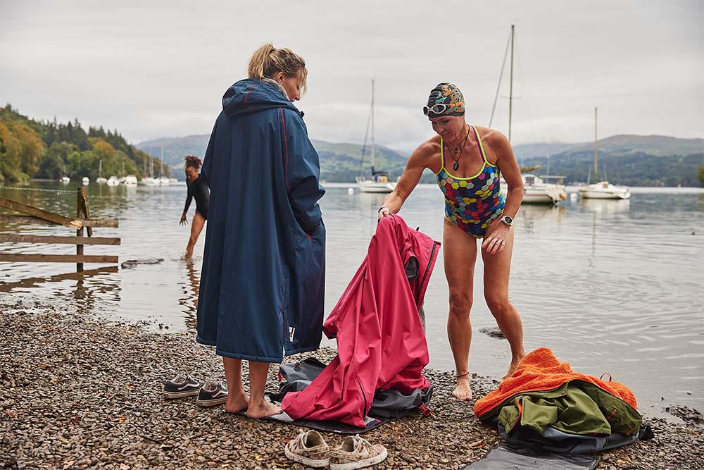 Women swimming and putting on Red Original waterproof changing robes