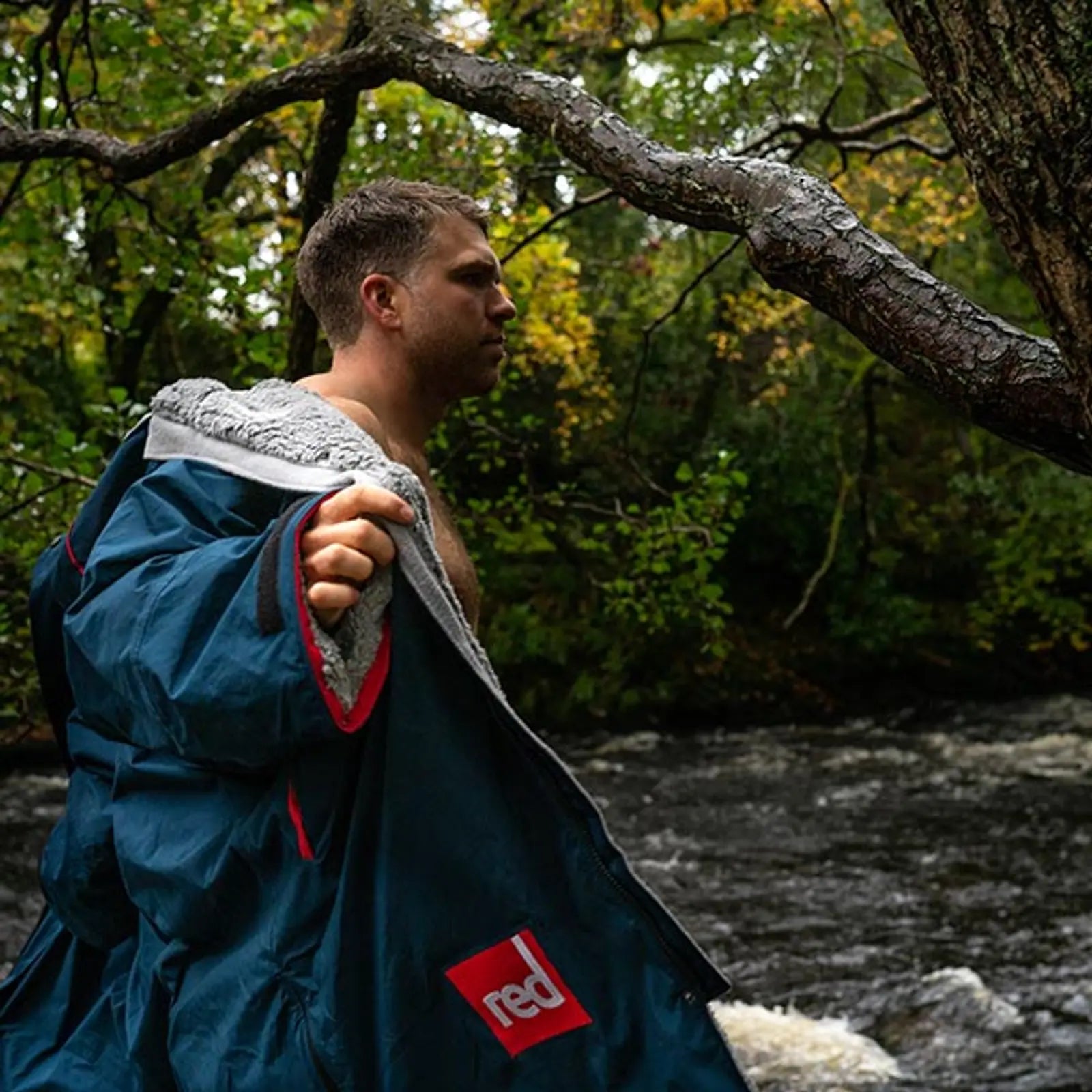 A man changing out of his Red Pro Change Robe to go swimming