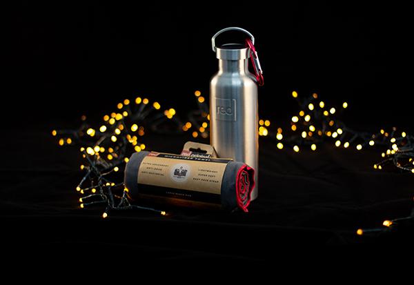 A Red Insulated Water Bottle and Microfibre Towel surrounded by fairy lights