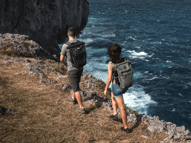 man and woman hiking with waterproof backpacks