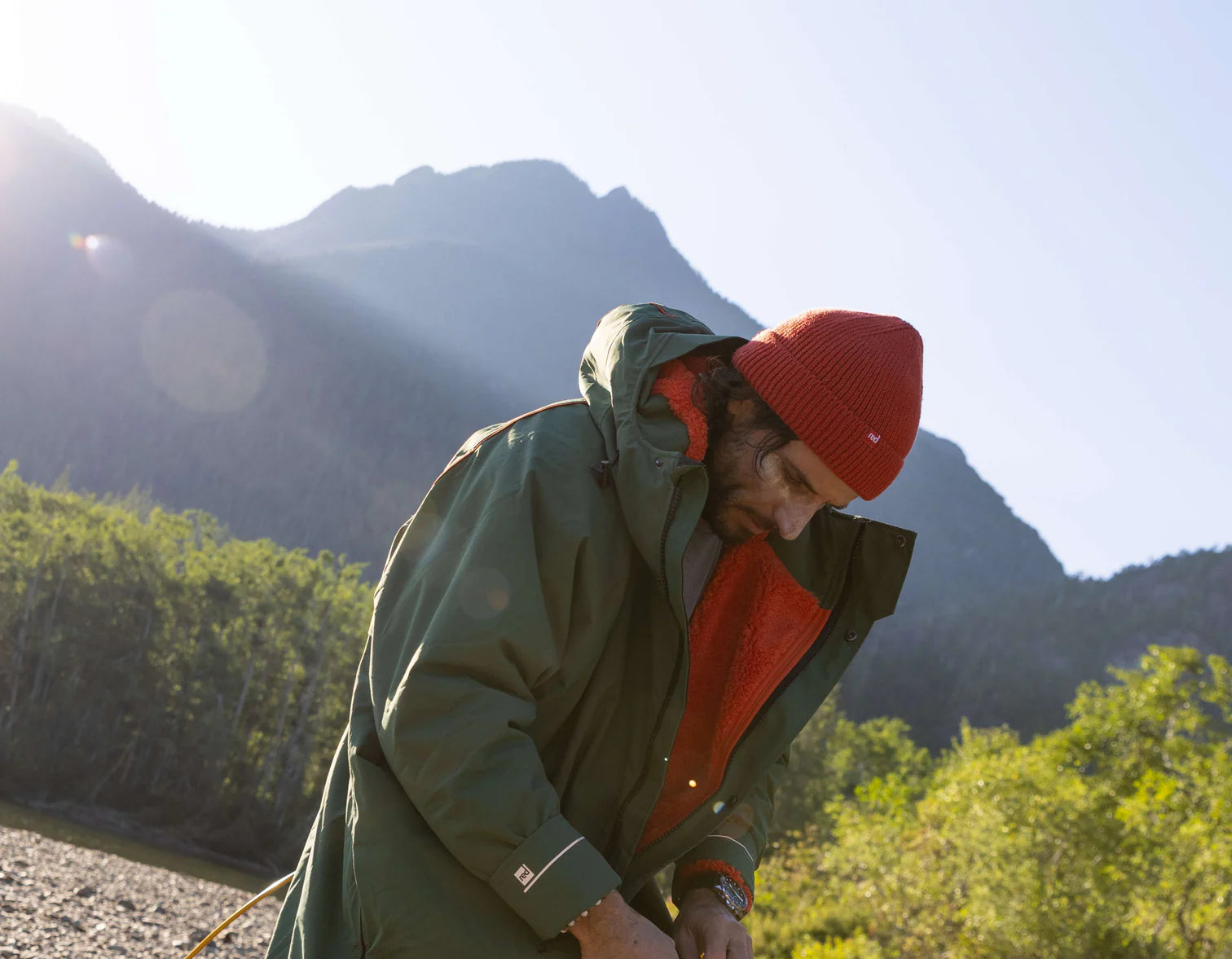 A man zipping up his changing robe whilst on a hike