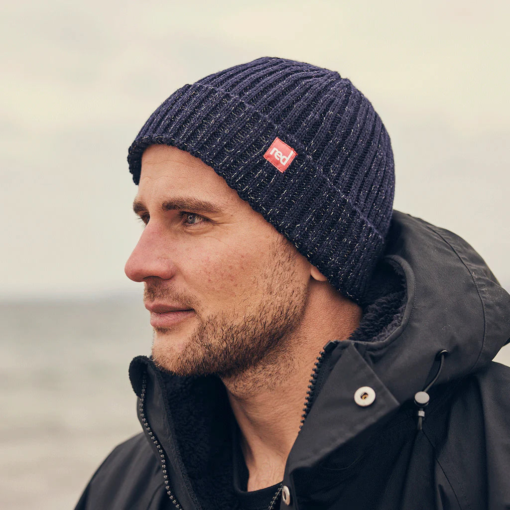 A man wearing the merino navy beanie, looking to the side