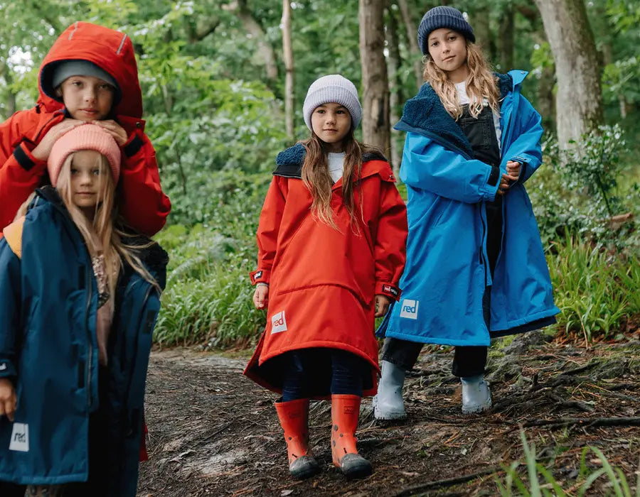 4 children wearing the Red Kids Dry Pro Change Robe in the woods