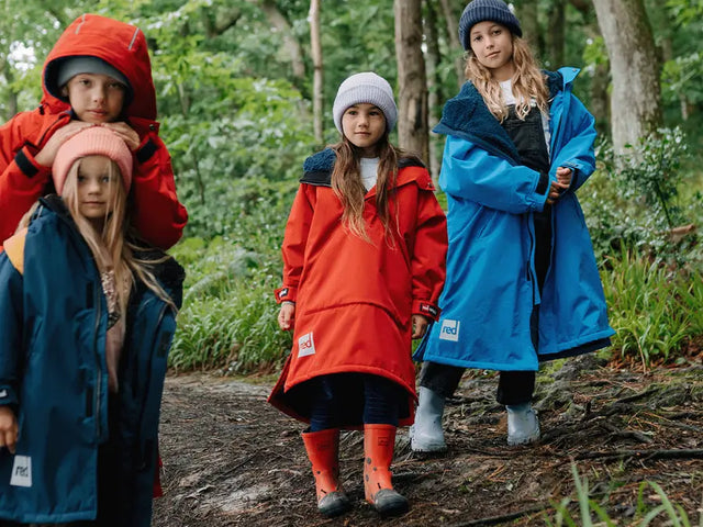 4 children wearing the Red Kids Dry Pro Change Robe in the woods