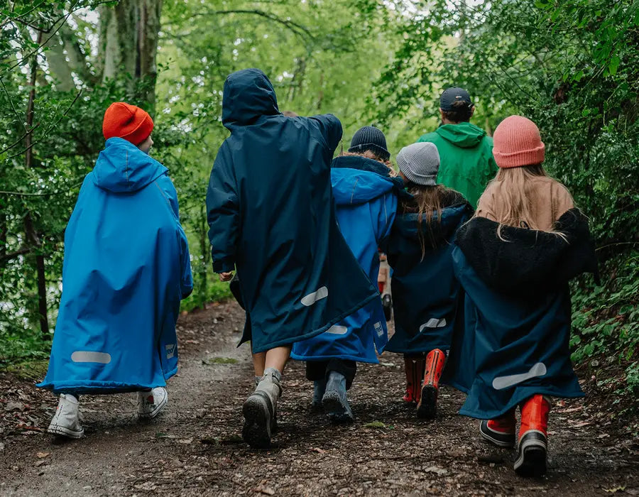 A group of children walking through the forest in their Red Pro Change Robes