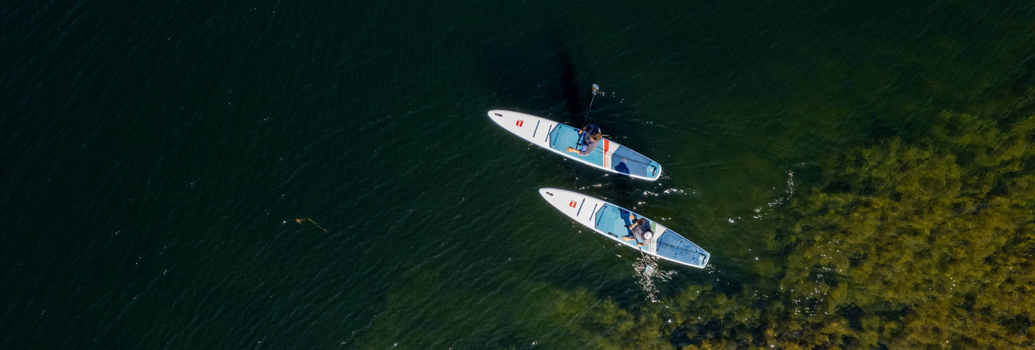 aerial view of paddleboarders on touring paddle boards