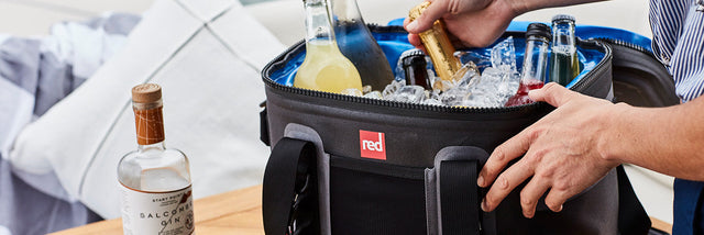 Lifestyle Shot Of Red Original Waterproof Cooler Bag filled with ice and bottles