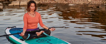 Woman Practicing Yoga On A Paddleboard