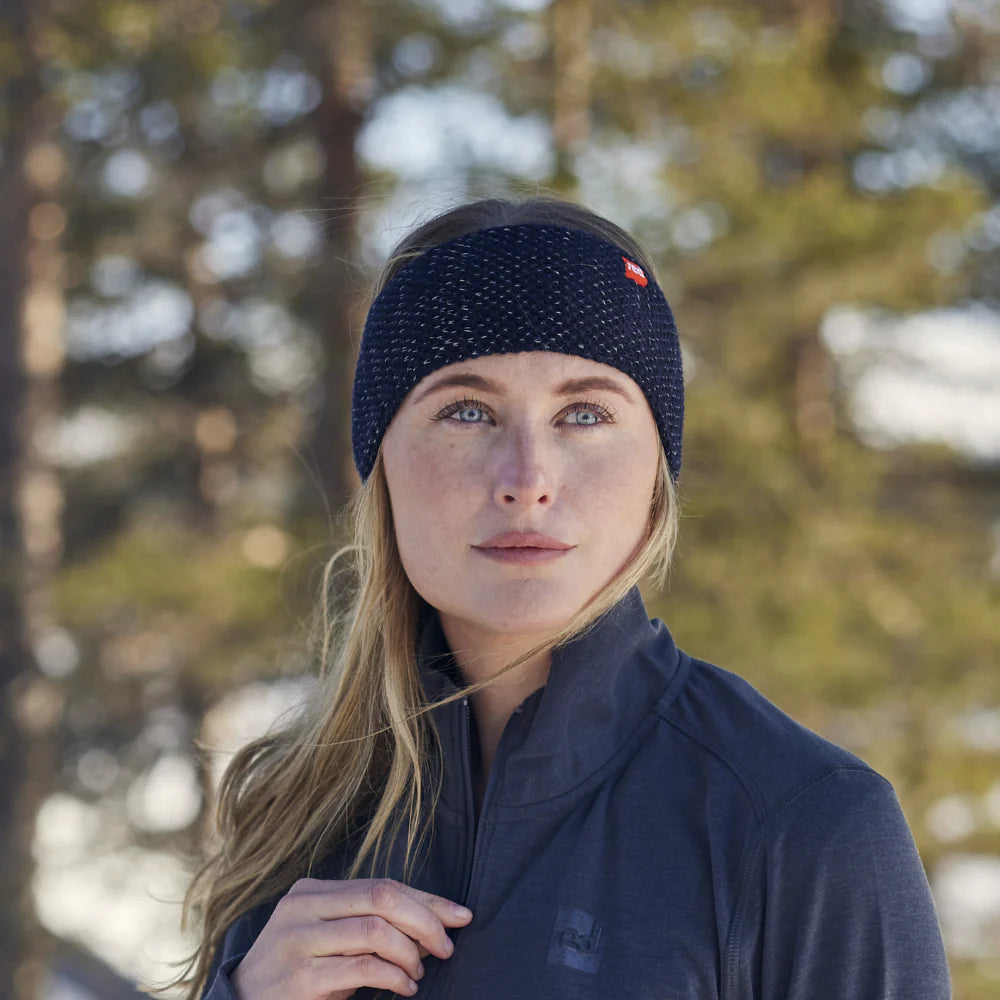 A woman wearing a navy merino headband, looking forward