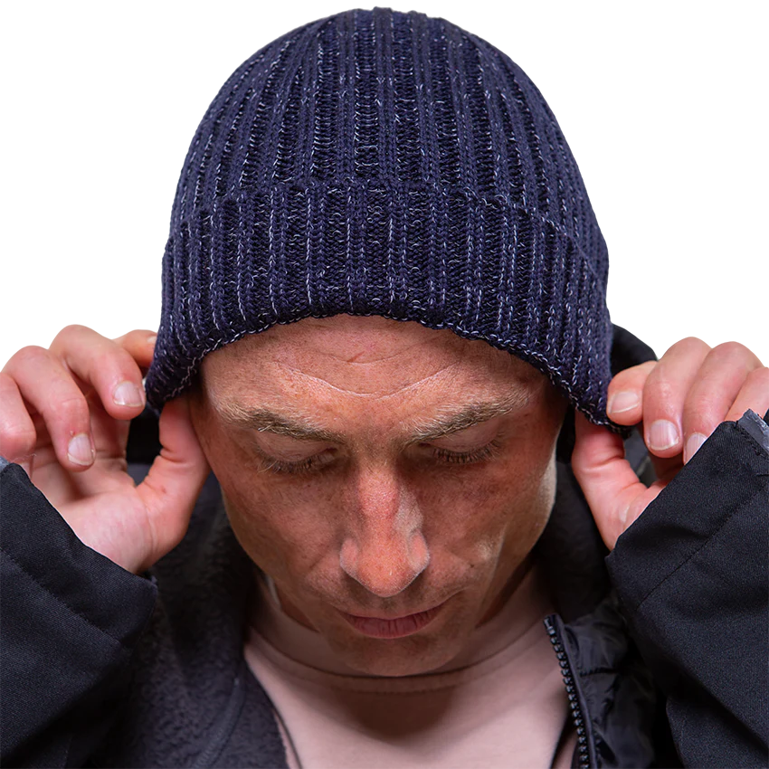 A man pulling on his navy merino beanie