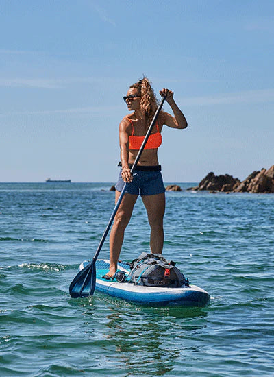 A woman paddleboarding on a sunny day in the sea